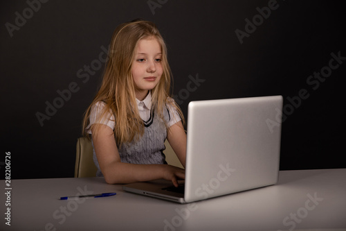 Happy little girl infront of the laptop typing isolated