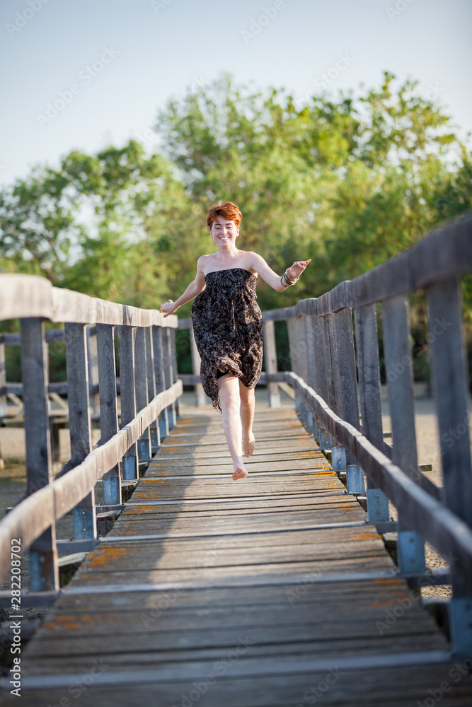 FREEDOM, HAPPY WOMAN RUNNING ON A GATEWAY. FREEDOM, HAPPY WOMAN RUNNING ON A GATEWAY.