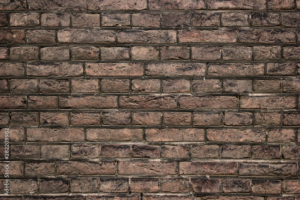 Old weathered brown brick wall background texture