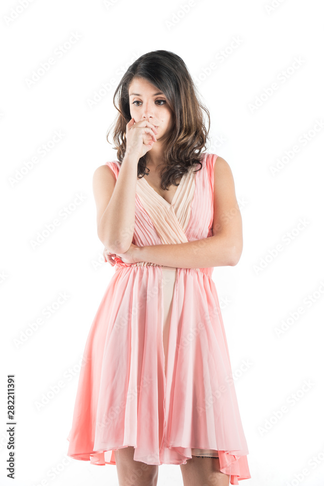 Isolated young woman on a pink dress while on deep thought