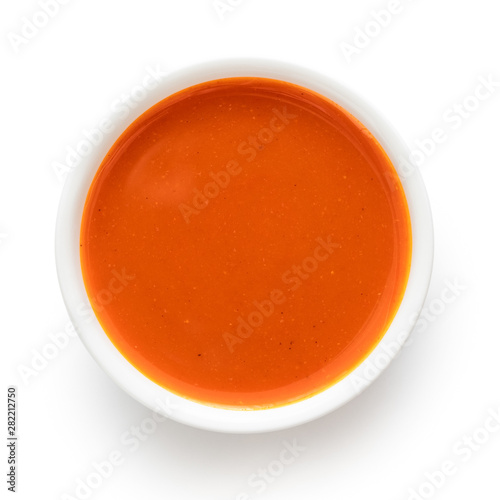Peri peri chilli sauce in a white ceramic bowl isolated on white from above.