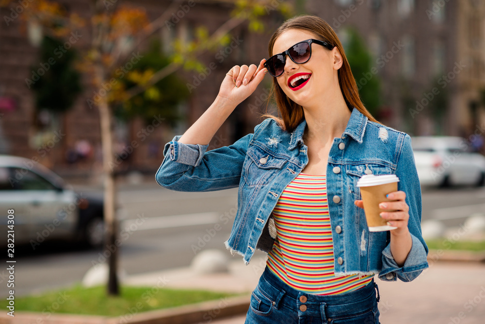 Portrait of cheerful millennial with foxy ginger haircut red pomade holding mug with beverage in city outdoors Portrait of cheerful millennial with foxy ginger haircut red pomade holding mug with beverage in city outdoors