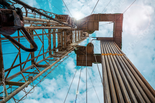 Oil and Gas Drilling Rig onshore dessert with dramatic cloudscape. Oil drilling rig operation on the oil platform in oil and gas industry.