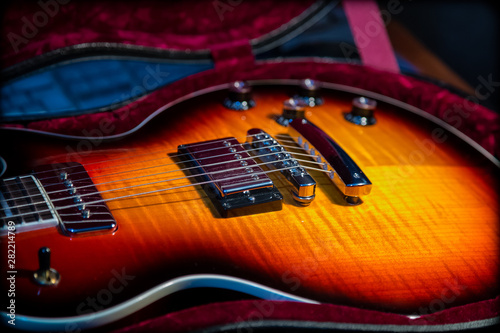 Сlose-up of electric guitar with flame maple top in beautiful light