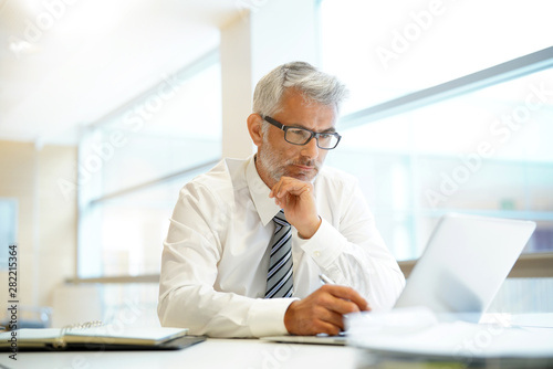 Relaxed mature businessman working in contemporary office