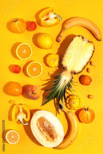 Fototapeta Naklejka Na Ścianę i Meble -  Assorted vegetables and fruits in yellow on a yellow background. Top view