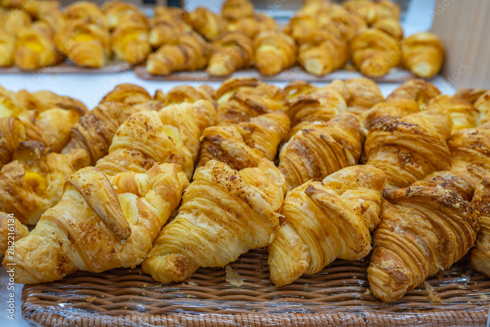 Pile of puffy croissants on shelf for sale at patisserie Pile of puffy croissants on shelf for sale at patisserie