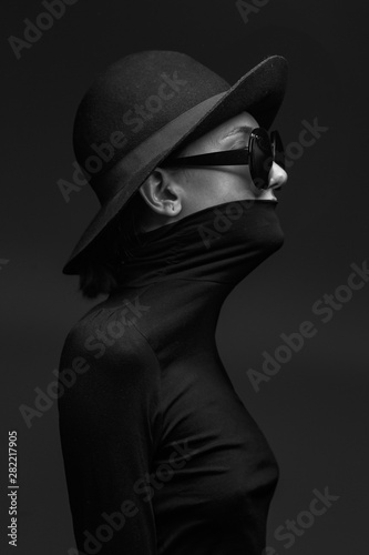 Fotografie Stylish black and white portrait of elegant slim girl in glasses and a hat