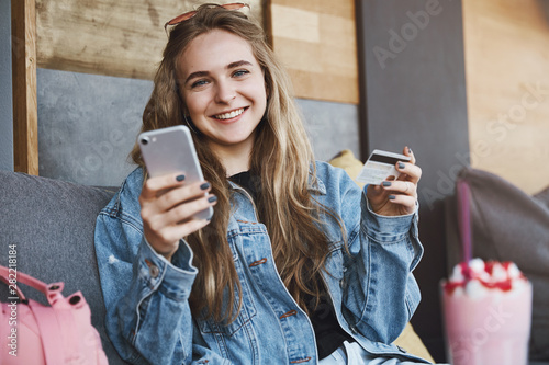 Slika na platnu Friends sitting in cute cafe, drinking and talking while attractive blonde stude
