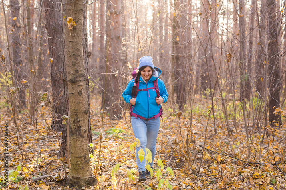 adventure, travel, tourism, hike and people concept - Attractive smiling tourist woman walking in the thick of the forest adventure, travel, tourism, hike and people concept - Attractive smiling tourist woman walking in the thick of the forest