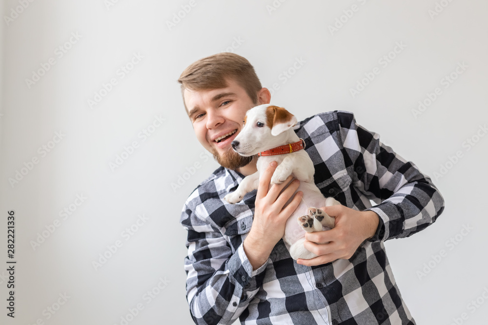people, pets and dogs concept - young man hugging funny puppy on white background people, pets and dogs concept - young man hugging funny puppy on white background