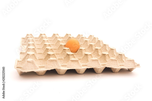 one egg lying on egg box isolated on white background.
