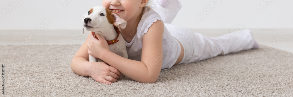 Pet, children and animal concept - Adorable child girl and funny puppy having fun close-up Pet, children and animal concept - Adorable child girl and funny puppy having fun close-up