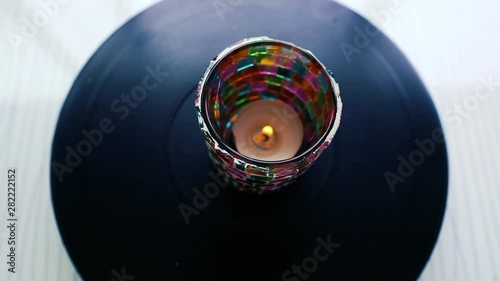 Candle rotating on dark background. Candle in colorful jar