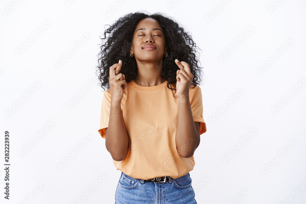 Girl hopes god hears prayers making wish desire come true. Hopeful attractive young female student wishes pass university exams close eyes raise head sky, cross fingers good luck white background Girl hopes god hears prayers making wish desire come true. Hopeful attractive young female student wishes pass university exams close eyes raise head sky, cross fingers good luck white background