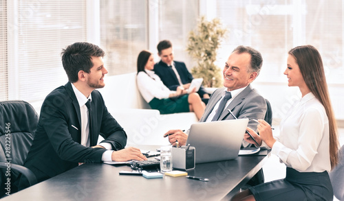 Business partners are discussing a plan of cooperation against the background of team work