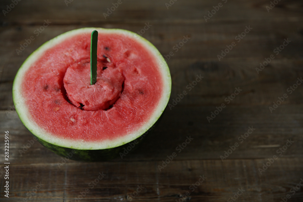 red ripe watermelon with cut out middle on a wooden chopstick on a wooden rustic background with copy space for text. Organic Healthy food. Diet, detox. red ripe watermelon with cut out middle on a wooden chopstick on a wooden rustic background with copy space for text. Organic Healthy food. Diet, detox.