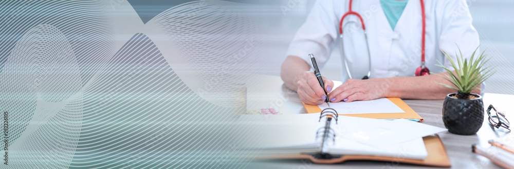 Female doctor writing a medical prescription; panoramic banner Female doctor writing a medical prescription; panoramic banner