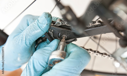 The mechanic is fixing the road bicycle in his workshop