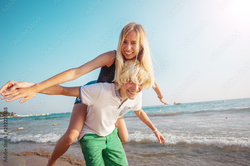 Fototapeta premium Happy young couple having fun at beach on sunny day