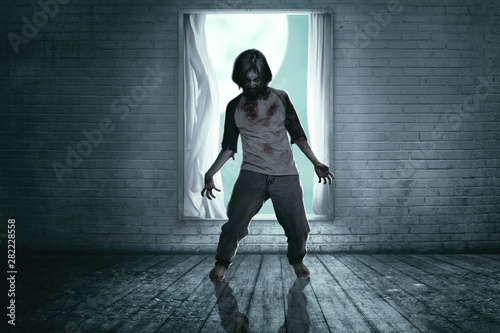 Scary zombies with blood and wound on his body haunted the abandoned house