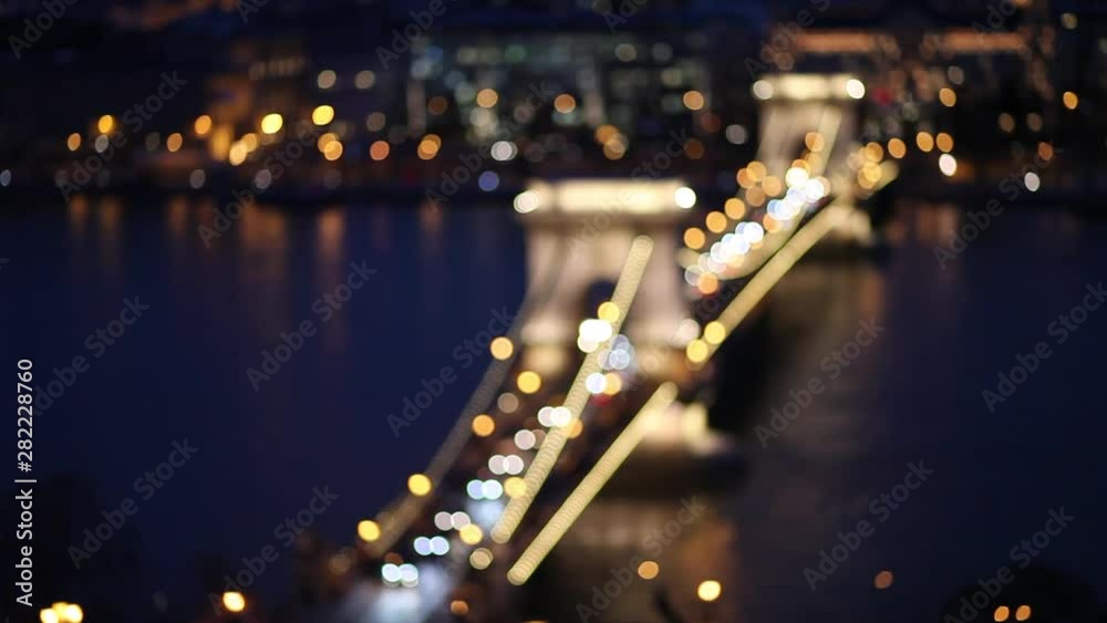 Car traffic night city lights blurred bokeh background. Video of night city road. Cars and bus moving on road on bridge in night. Budapest, Hungary