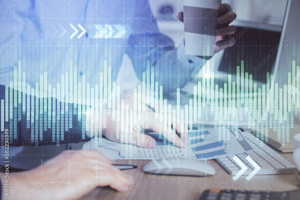 Multi exposure of chart with man typing on computer in office on background. Concept of hard work. Multi exposure of chart with man typing on computer in office on background. Concept of hard work.