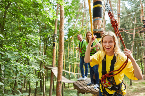 Woman is laughing proudly in the climbing forest on a bridge photo