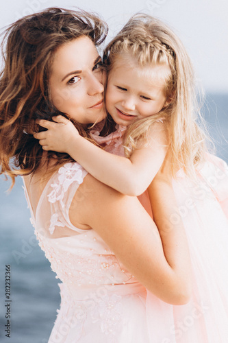 Mother and Daughter in pink dresses. Family.