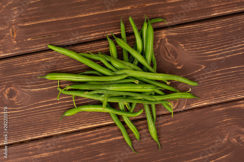Lot of whole fresh green bean flatlay on brown wood