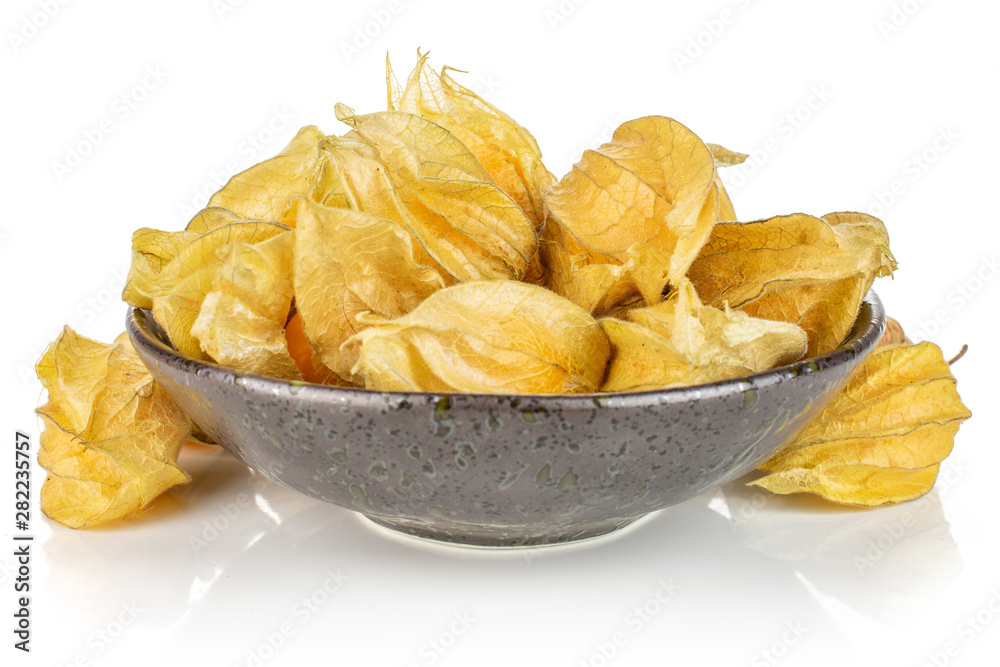 Lot of whole fresh orange physalis in dark ceramic bowl isolated on white background Lot of whole fresh orange physalis in dark ceramic bowl isolated on white background