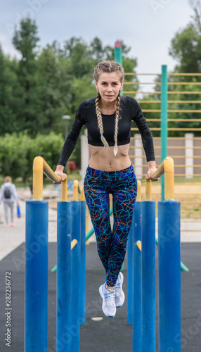Fototapeta Naklejka Na Ścianę i Meble -  Beautiful athletic girl is training on uneven bars