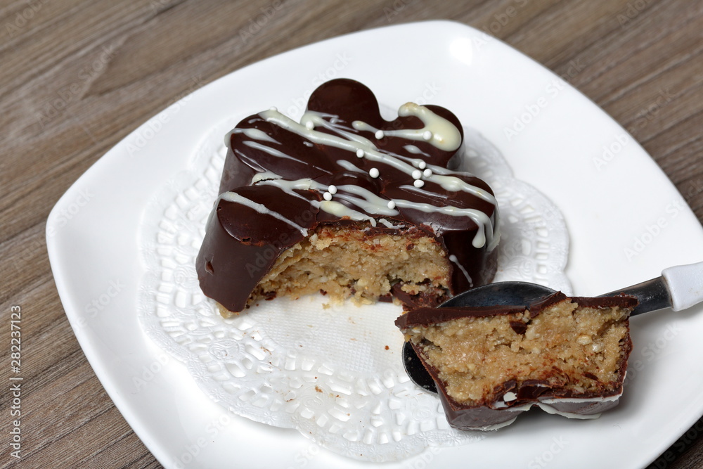 Chocolate dessert in the shape of a flower. Dark chocolate coated. Garnished with white chocolate and sprinkles. Chocolate dessert in the shape of a flower. Dark chocolate coated. Garnished with white chocolate and sprinkles.