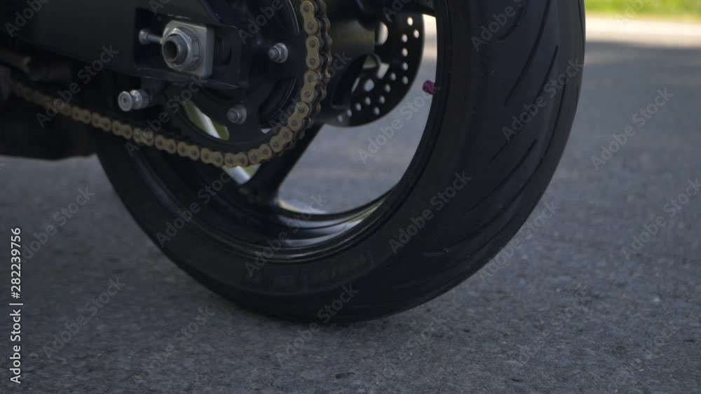 Detailed shot of Suzuki 750 GSXR motorbike, spinning wheel, smoke Detailed shot of Suzuki 750 GSXR motorbike, spinning wheel, smoke