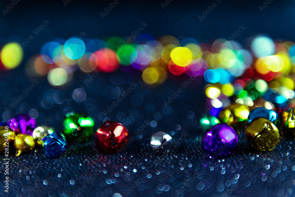Multi-colored Christmas jingle bells. Blue filter. Blurred bokeh background. - obrazy, fototapety, plakaty 