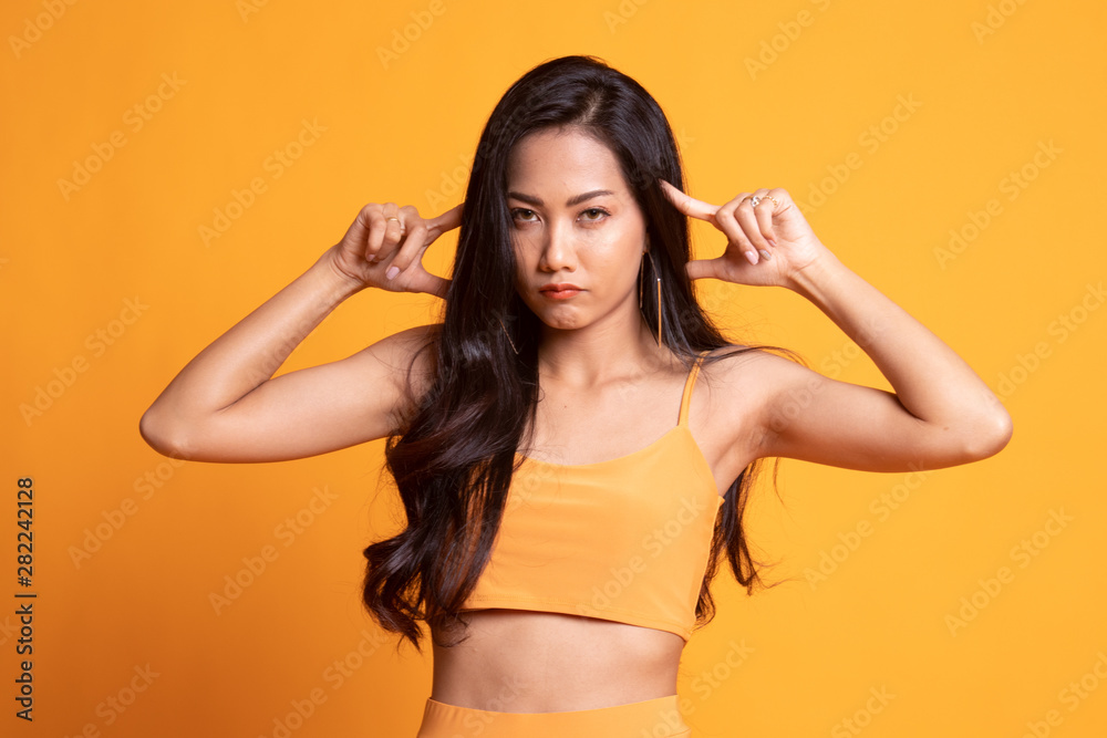 Young Asian woman block both ears with fingers. Young Asian woman block both ears with fingers.