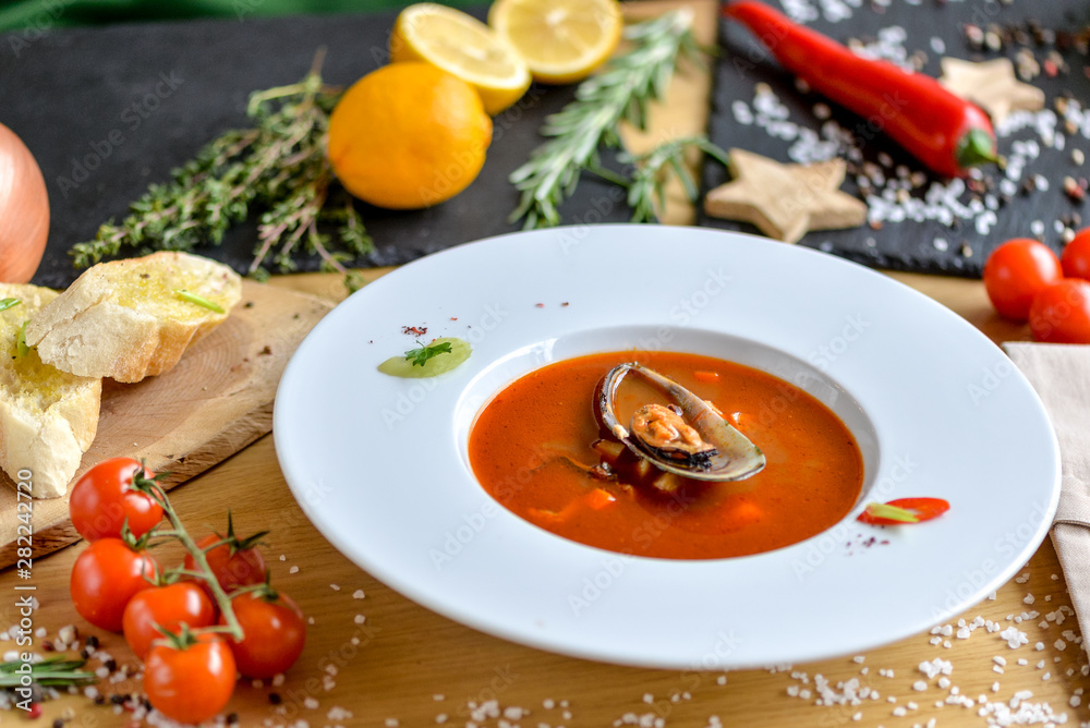 cream tomato soup with mussels on a round plate with beautiful food styling cream tomato soup with mussels on a round plate with beautiful food styling