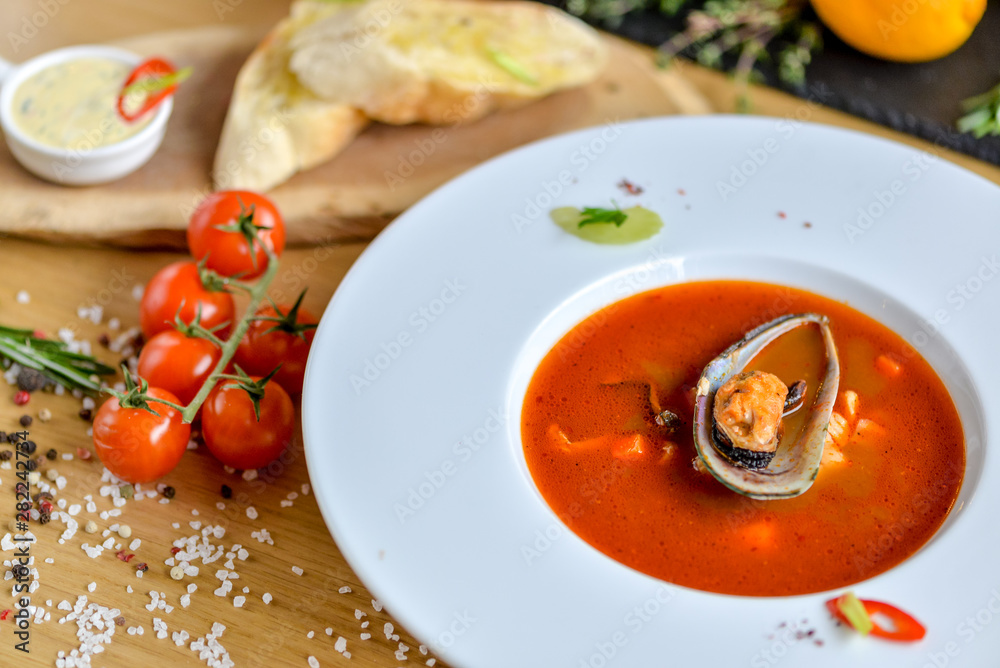 cream tomato soup with mussels on a round plate with beautiful food styling cream tomato soup with mussels on a round plate with beautiful food styling