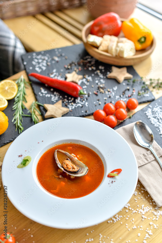 cream tomato soup with mussels on a round plate with beautiful food styling cream tomato soup with mussels on a round plate with beautiful food styling