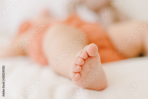 Partial View of New Born Baby Leg Slipping in Bed. Closeup Picture of Adorable Infant Tiny Foot on Beige Blanket Selective Focus. Calm Little Child Lying. Caucasian Toddler Napping © oksana_bondar