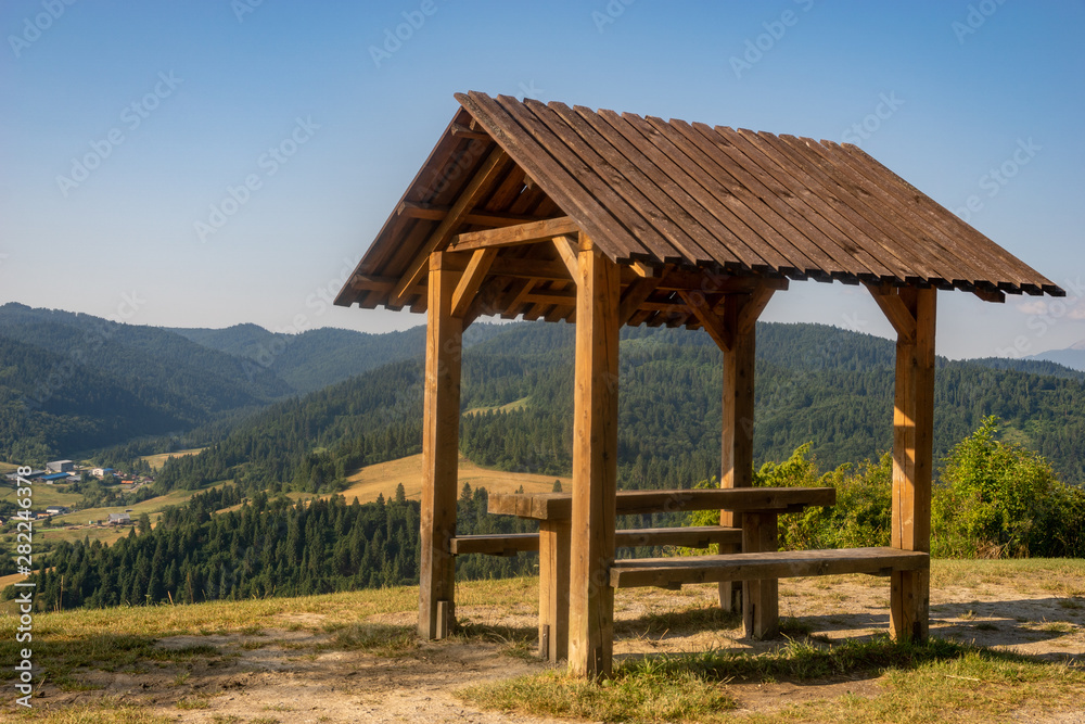 covered gazebo with table and benches overlooking the mountains