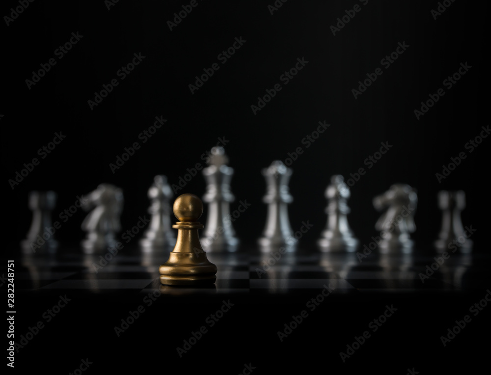 Golden chess pawn is facing the silver opponent chess on black background. Leader, leadership, business strategy, challenge, brave or fearless concept. Golden chess pawn is facing the silver opponent chess on black background. Leader, leadership, business strategy, challenge, brave or fearless concept.