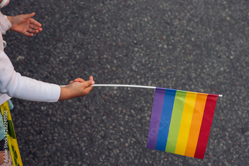 Canvas Print Child waiving the colorful rainbow Pride flag in the Pride parade in Stockholm