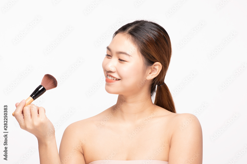 Beautiful Asian young woman smile and holding make up brush with healthy Clean and Fresh skin feeling so happiness and cheerful,Isolated on white background,Beauty Concept Beautiful Asian young woman smile and holding make up brush with healthy Clean and Fresh skin feeling so happiness and cheerful,Isolated on white background,Beauty Concept