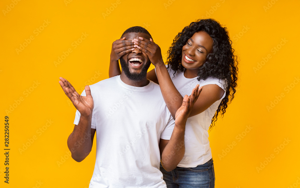 Pretty afro woman closing her man eyes from behind - obrazy, fototapety, plakaty 