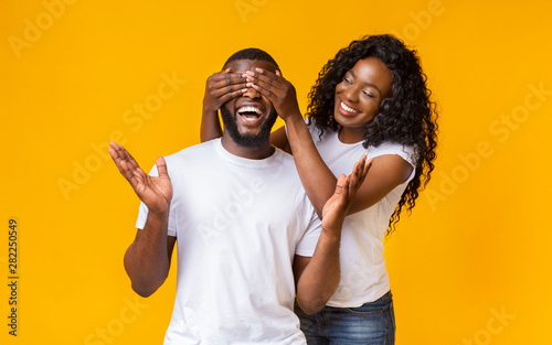 Pretty afro woman closing her man eyes from behind