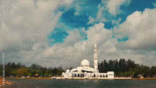 Timelapse footage of Tengku Tengah Zaharah Mosque or Floating Mosque in Kuala Terengganu, Malaysia with perfect reflection with fast moving clouds under bright sunny day
