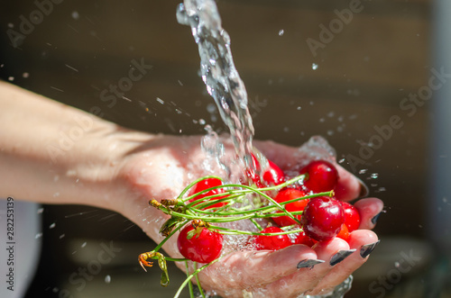 The woman is washing the cherries in her hands.