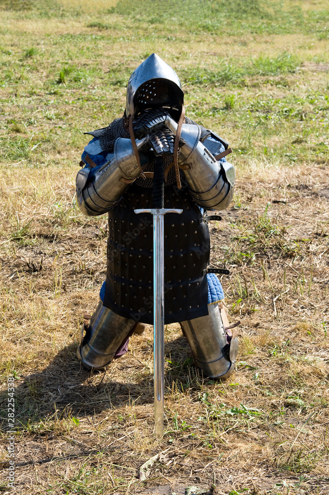 Medieval knight in protective armor, helmet and sword. Medieval knight in protective armor, helmet and sword.