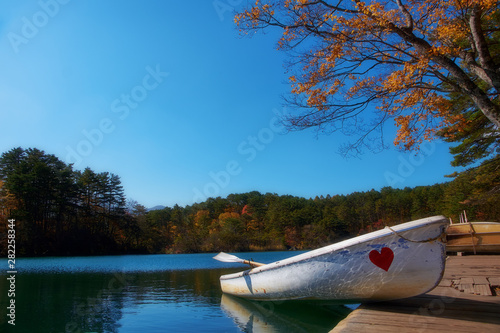 Vibrant autumn colors (foliage) at Goshiki-numa five colour pond. Row boat at port, Urabandai, Fukushima Prefecture, Japan photo